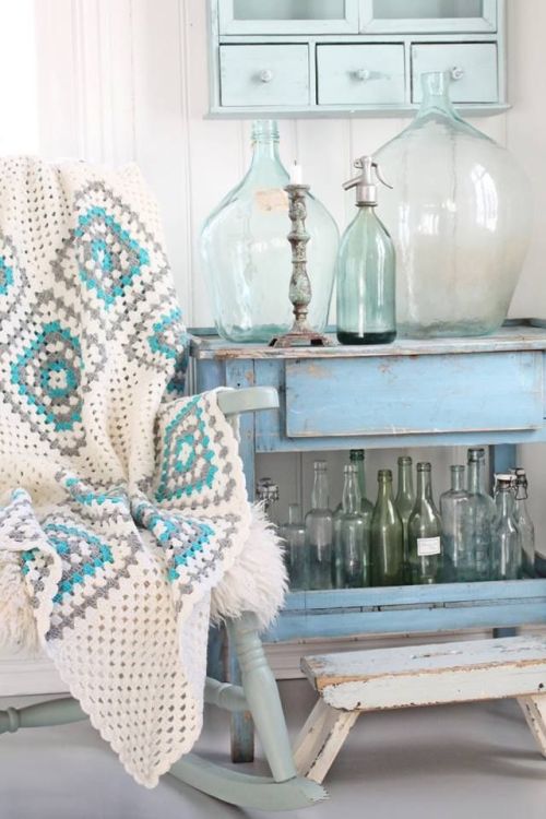 Vintage sea glass bottles covering a weathered sideboard