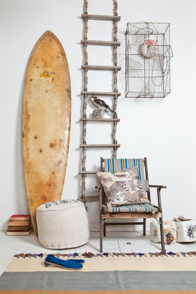 Coastal details including weathered looking wood furniture and an old surfboard