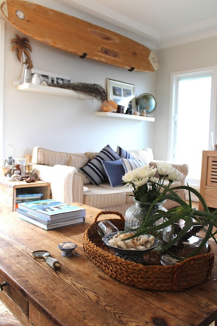 Cozy, coastal cottage with fun beach decor like the shells and surfboard mounted on the wall