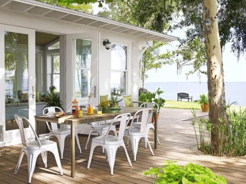 Coastal outdoor dining area with french inspired tolix style chairs