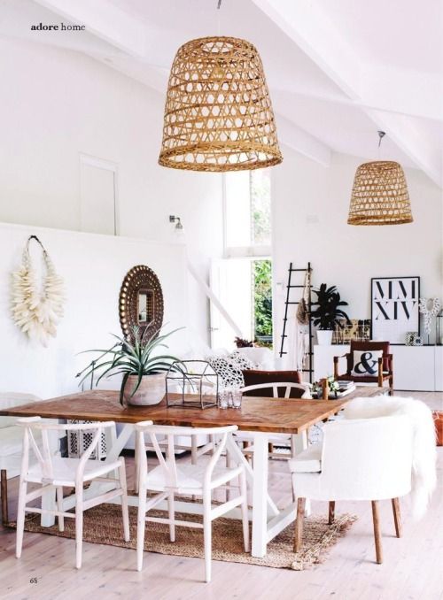 Eclectic space with coastal influence, large natural material pendant lighting, white chairs and unique decor