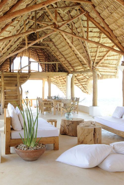 Tropical home with a thatched roof and simple wood furniture