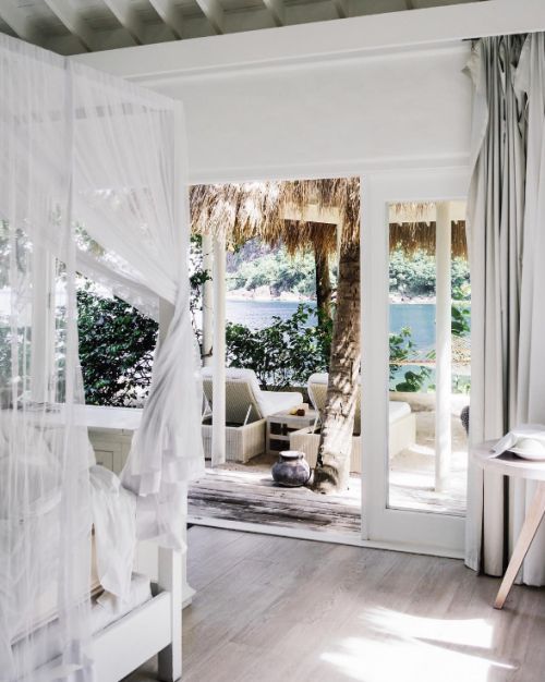 Coastal bedroom leading out into a tropical paradise