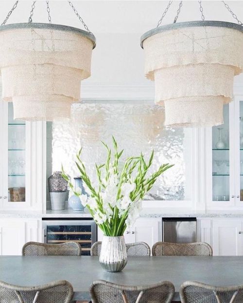 Large chandeliers hanging above a coastal dining table