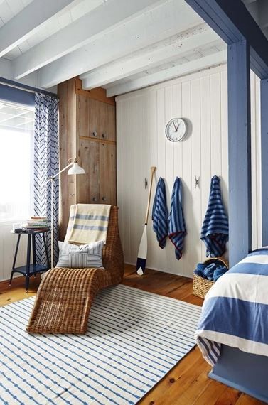 Coastal bedroom decorated in blue heus and a wicker style chair